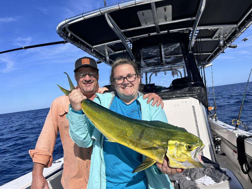 a man and woman show off their nice mahi caught with SeaCo Fishing Charters while offshore fishing in St. Augustine, Florida