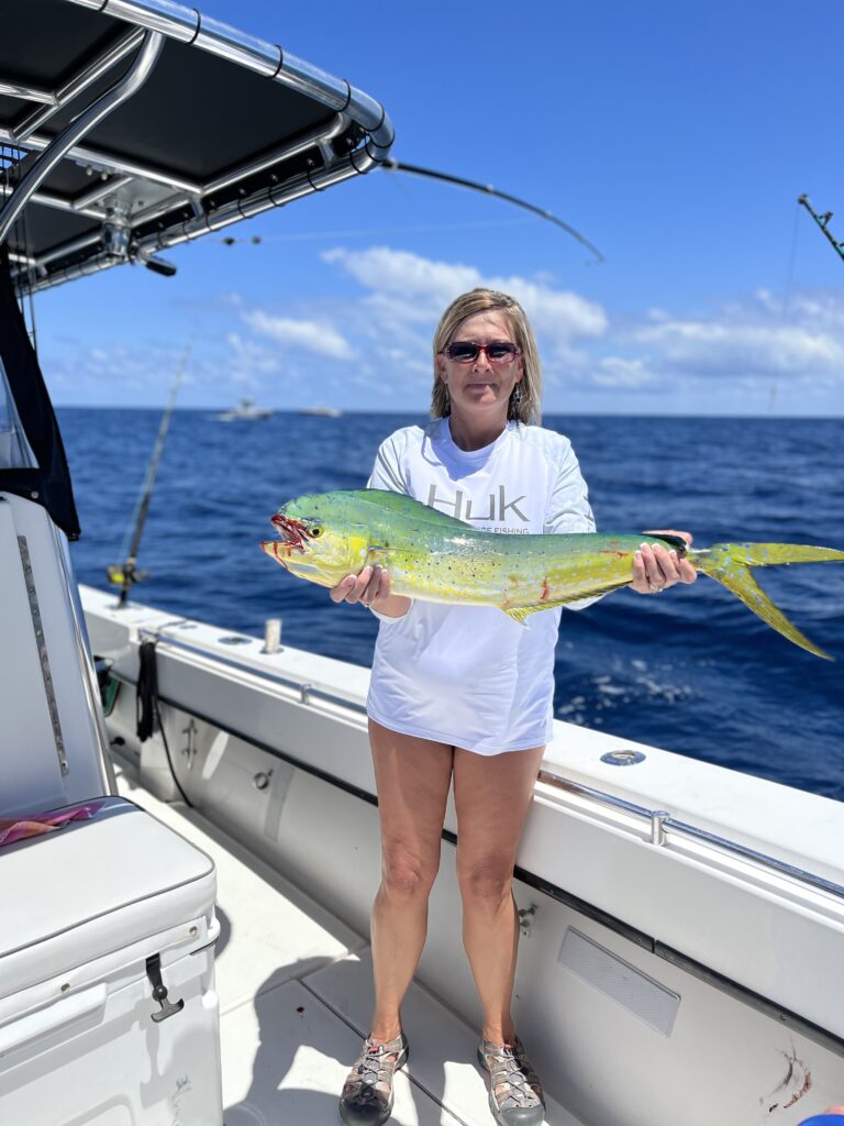Lady Angler shows off her mahi catch during an offshore fishing trip with SeaCo Fishing Charters in St. Augustine, FL