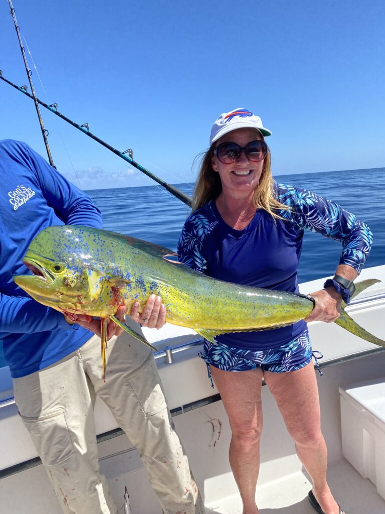 A lady angler shows off a beautifully lit-up Mahi-mahi caught on a trolling trip with Captain Ricky Poupore, SeaCo Fishing Charters in St. Augustine FL