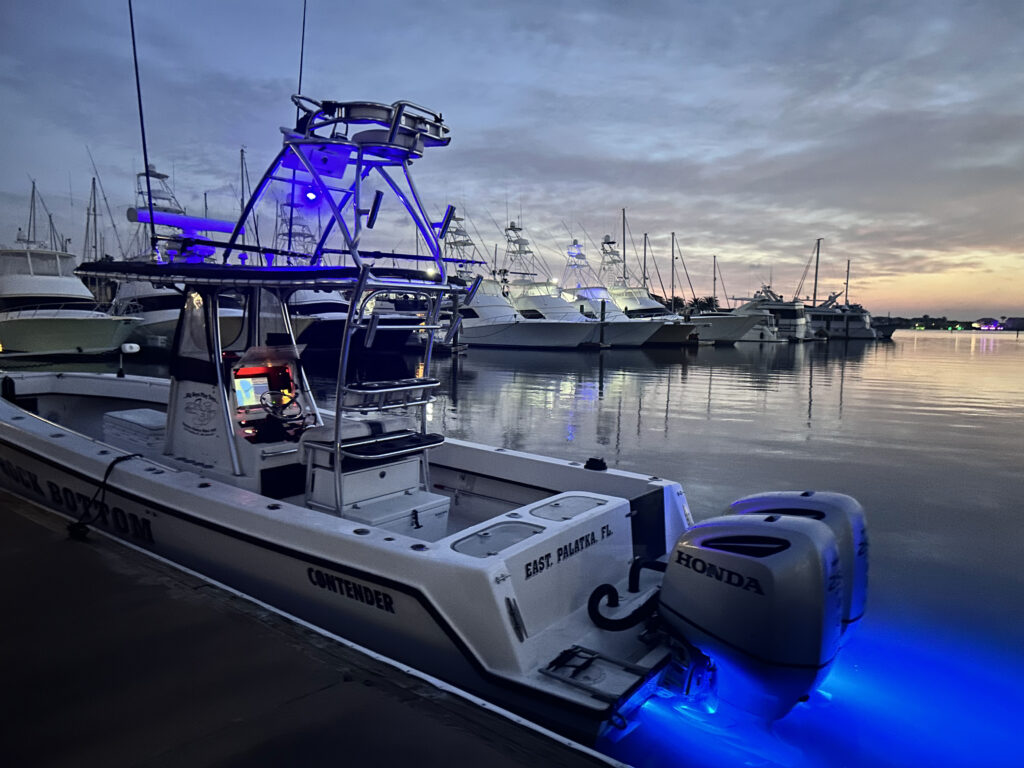 SeaCo Fishing Charters fishing vessel "Rock Bottom" sits in the Camachee Cove Yacht Harbor Marina on a calm morning with a sunrise
